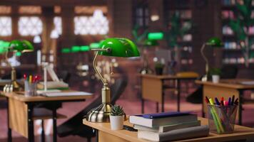 Refined vintage library with wooden shelves and classic green lamps, a calm workspace for booklovers. Empty study area perfect for learning, reading or enjoying the charm of a scholarly setting. video