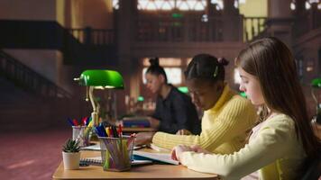 Teen girls reading books in the library to focus on mandatory literature and gaining knowledge for academic curriculum during study time. Young scholars focusing on lecture tasks. Camera A. video