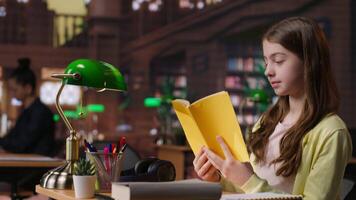 Teenager immersed in reading literary works from the school library database, focusing on her education and preparing for mandatory assignments or lectures. Diligent girl loves to read. Camera B. video