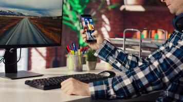 Man at home watching social media live broadcasts, interacting in chat with online content creators. Person holding phone, using social network app to partake in livestreams, camera B video