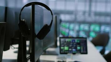 Close up of headphones left by worker on server room PCs used by employees working to ensure minimal downtime. Equipment in data center workplace used for monitoring performance video