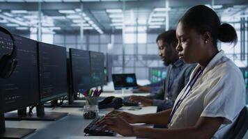 Close up of programmer in data center implementing AI predictive maintenance systems. Focus on IT professional in server hub using artificial intelligence to identify hardware failures, camera A video