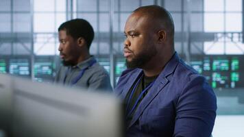 Portrait of happy server room worker developing disaster recovery plans ensuring minimal downtime. Smiling technician in data center using data analytics to monitor performance, camera A video