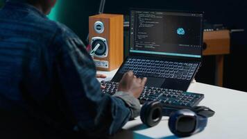 Computer scientist updating artificial intelligence neural networks, writing binary code scripts. Remote worker in apartment office uses digital device programming to upgrade AI, camera A video