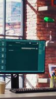 Computer setup in brick walls tech industry workspace showing large language model program. PC in IT home office with AI LLM chatbot answering user prompts using neural network, handheld camera shot video