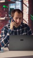 Manager at work arguing with employee during phone call after finding mistakes in spreadsheets on laptop. Team leader scolding worker during telephone call after finding errors in documents, camera A video