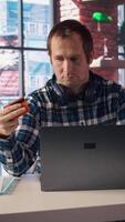 Man doing internet shopping, carefully typing credit card information on laptop in apartment. Shopper adding payment method on website while at home in living room, camera A video