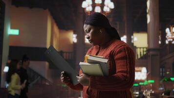 Female educator preparing her teaching materials and resources in the library, leveraging her expertise to mentor scholars and create a productive academic atmosphere for young minds. Camera A. video