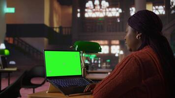 African american librarian working with academic resources next to copy space, managing learning materials within the public library database. Tutor woman focused on her profession. Camera A. video