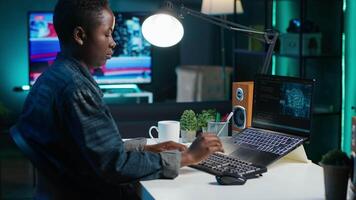 AI expert writes code on laptop in apartment office using Java programming languages. Artificial intelligence programmer remotely working on fixing database errors while working from home, camera A video