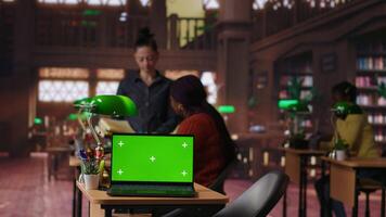 Diverse people working on their assignments in a library with green screen, finishing homework after classes. Schoolgirls discuss with tutors about literature, productive study sessions. Camera B. video
