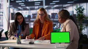 Diverse group of female colleagues ensuring goals achievement next to chroma key display, believing in equal rights and women empowerment. Powerful businesswomen work with resilience. Camera B. video