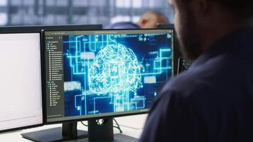 Machine learning expert in AI server room developing disaster recovery plans ensuring minimal downtime. Employee monitoring performance in artificial intelligence ran data center, camera A video