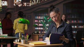 Professional author and librarian working on new notes in a public library, focused on academic resources and guidance for success. Woman collecting educational information. Camera A. video