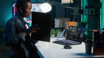 Manager talking with collaborator working from home, holding teleconference meeting to present project. Team leader talking with employee showing charts on clipboard during online videocall, camera A video