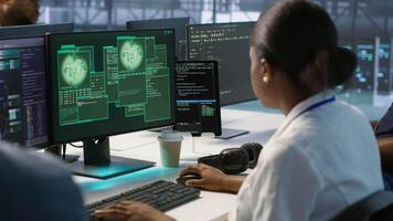 Team of engineers in server hub trying to protect gear from hacker stealing sensitive information. Data center coworkers struggling to erase virus after seeing security breach notification, camera A video
