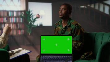 Army veteran at counseling shares war related anxiety next to isolated screen, discuss about psychological issues and infantry shell shock syndrome. Trooper listens to professional advice. Camera A. video