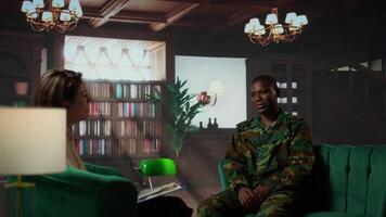 Portrait of army trooper meeting with a counselor to discuss about anxiety and distress due to PTSD and battle trauma, shell shock and mental disorder. Depressed trooper at counseling. Camera B. video
