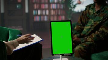African american trooper in therapy shares war trauma next to chroma key, experiences psychological issues and anxiety due to combat flashbacks. Veteran listens to professional advice. Camera A. video