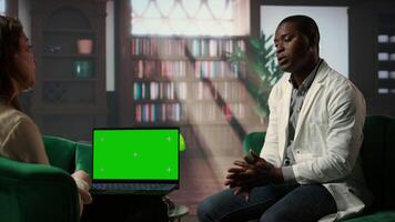 Professional counselor holds a copy space tablet in therapy session with medic, consulting doctor with trauma after losing patients. Discussing stress disorder and anxiety in his career. Camera A. video