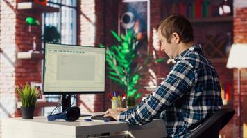 Software developer at computer coding, stretching joints after sitting at desk too long. IT expert in home office doing muscle exercises after feeling pain from incorrect posture, camera B video