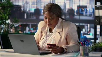 Black chief executive officer paying for something via credit card banking, making a purchase on discount with e wallet. Entrepreneur entering card credentials on website for shopping. Camera A. video