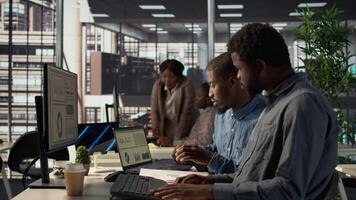 africano americano equipe examina por mês receita Saldo em uma computador, planejamento Próximo passos dentro financeiro operações para garantir fecundo investimento. trabalhadores revendo desempenho Métricas. Câmera b. video