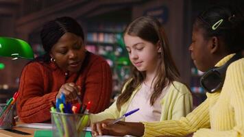 Female teacher assisting pupils with class homework and mentoring, providing academic instruction and support to help pass school assignments. Tutor lecturer gives private lessons. Camera B. video