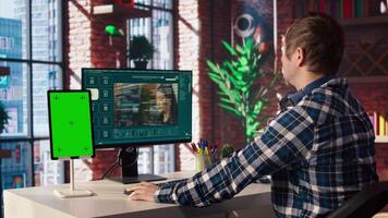 Man watching guide on mockup device about generative artificial intelligence generating videos. Man looks at tutorial on green screen tablet about AI virtual assistant producing clips, camera A video