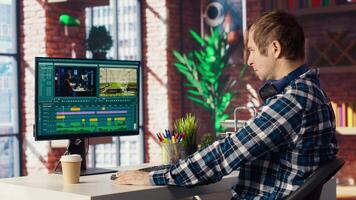 editor selecting key frames to use while doing montage, working from home on computer. Man using mouse to edit movie project footage in apartment home office, camera B video