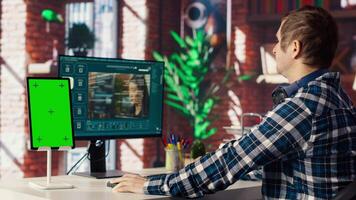 Man watching guide on mockup device about generative artificial intelligence generating videos. Man looks at tutorial on green screen tablet about AI virtual assistant producing clips, camera B video