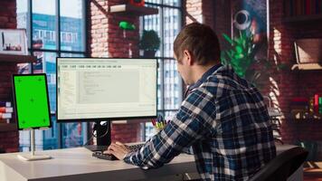 Software engineer at computer coding, creating software using isolated screen tablet. IT specialist in home office working with code editor, building applications using PC and mockup device, camera A video