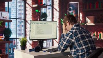 Software developer at computer waiting for code to finish compiling, yawning, feeling bored. Impatient man tired to wait for algorithms building scripts to finish, camera A video