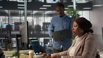 African american team members engaged in administrative tasks with archived files, reviewing data reports and corporate analytics to ensure alignment with enterprise goals for success. Camera B. video