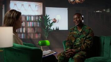 Black military officer in army uniform attends counseling session, looking distressed and opening up about post traumatic combat stress. War soldier dealing with shell shock. Camera A. video