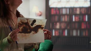 Armed forces veteran in uniform sits with a therapist during counseling, viewing a Rorschach test illustration to share feelings and discuss trauma. PTSD and shell shock syndrome. Camera B. video