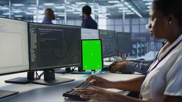 Programmers use isolated screen tablet in server room, developing disaster recovery plans ensuring minimal downtime. Data center employee looking at chroma key device, monitoring performance, camera A video