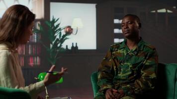 Psychotherapy session for an armed forces veteran in distress and grief, showcasing therapy for PTSD, trauma and reintegration after combat. Soldier dealing with war flashbacks. Camera B. video