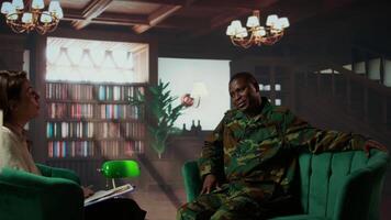 Portrait of black soldier attending a counseling session with therapist, sharing his feelings about losing troopers due to combat. Army veteran dealing with PTSD and shell shock. Camera B. video