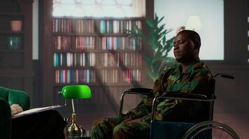 Black army soldier in wheelchair is a war survivor and deals with shell shock, experiencing a bad case of PTSD and anxiety. Wounded trooper opening up about horror combat scenes. Camera B. video