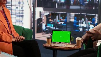 Multiethnic team of experts sharing insight next to chroma key screen, evaluating the performance metrics of the company and the staff. Female leaders analyzing data infographics. Camera A. video