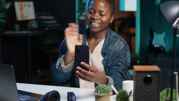 Woman receiving phone call, talking with best friend during videoconference using smartphone. Person waving hand, saluting mate in mobile phone online videocall session at home, camera A video