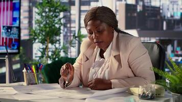 Black corporate owner drafting architectural sketches for a new office, looking to relocate startup headquarters. Collaborates with contractors to design a functional creative workspace. Camera A. video