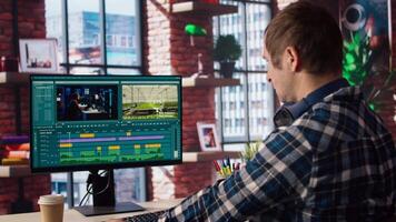 editor selecting key frames to use while doing montage, working from home on computer. Man using mouse to edit movie project footage in apartment office, camera A video