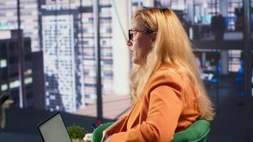Determined businesswoman speaking on a phone call to ensure project development success, multitasking in a corporate office. Female CEO using remote connection on her smartphone. Camera A. video