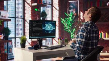 AI engineer in home office stretching back while looking at PC screen, feeling fatigued while executing code. Artificial intelligence developer feeling backpain, relieving pain, testing code, camera A video