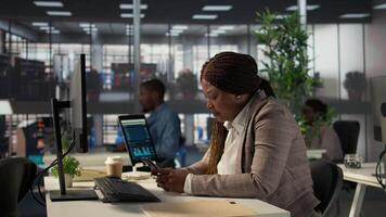 afrikansk amerikan chef tar en ha sönder från företag arbete och bläddring social media, checkar meddelanden och webbplatser på henne skrivbord. analytiker göra flera saker samtidigt och textning under schema. kamera b. video