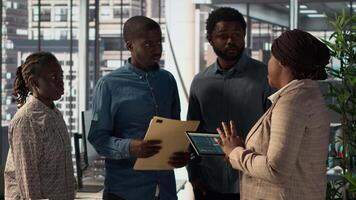 African american manager examines company strategy with her staff in a high end office, making key business decisions to support enterprise development. Establish resource allocation. Camera A. video
