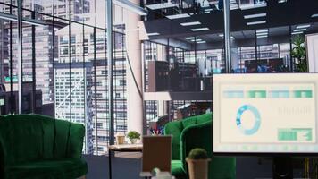 Modern office space with financial data on a monitor used for meetings, running detailed analytics and graphs. Empty workspace to develop business strategies for success, productivity tools. video
