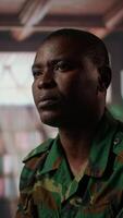 Vertical Armed forces trooper deals with depersonalization syndrome due to combat PTSD, feeling distressed and dissociative during therapy session. Black soldier with shell shock and trauma. Camera A. video